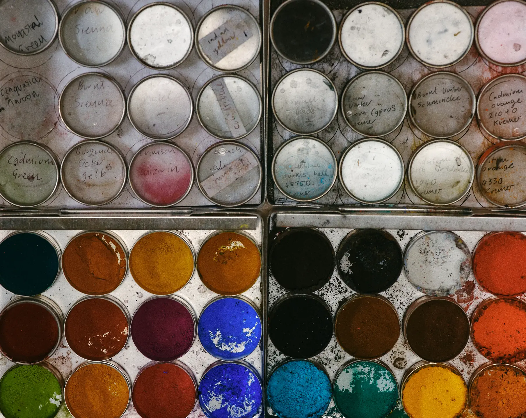 A photo of a small pots containing pigments.